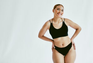 Empowered woman proudly posing in bra and underwear, showcasing her body transformation after a weight loss journey. The image reflects confidence, self-acceptance, and the positive impact of achieving personal health and fitness goals.