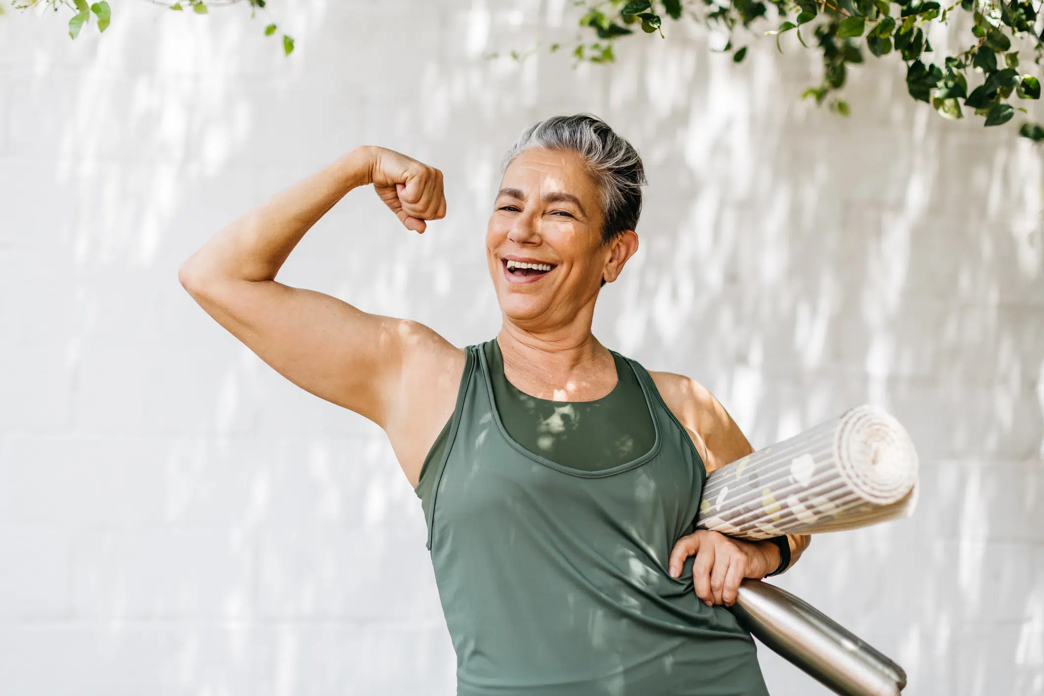 Photograph of a woman joyfully flexing her muscles, celebrating her achievement after weight loss. The image radiates positivity, strength, and self-confidence, emphasizing the empowering journey of personal transformation through fitness and healthy lifestyle choices.